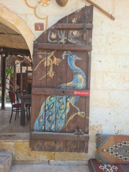 Páv na dveřích kavárny v Avanosu. 